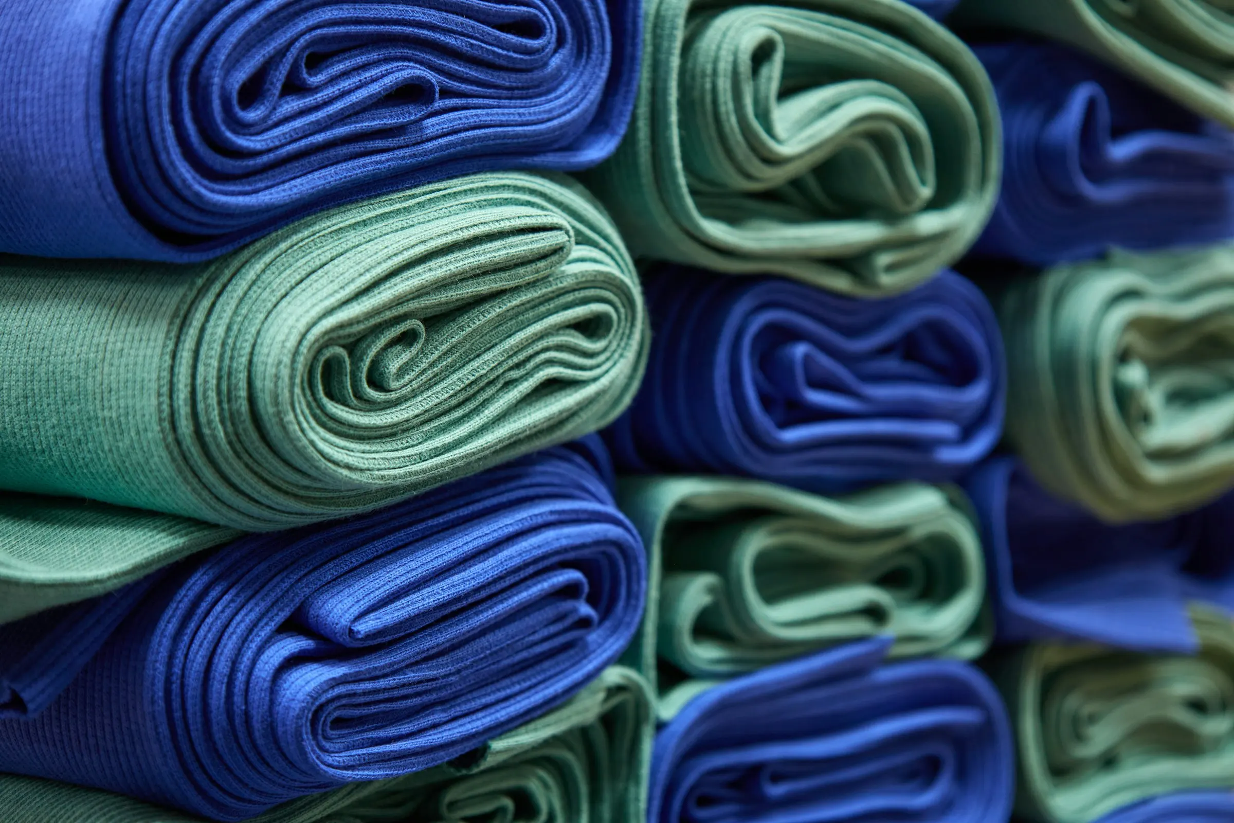 Rolos de malha azul e verde enrolados e empilhados